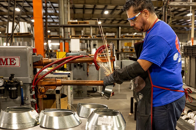 MMF Inc employee operating sheet metal fabrication machinery for HVAC duct products