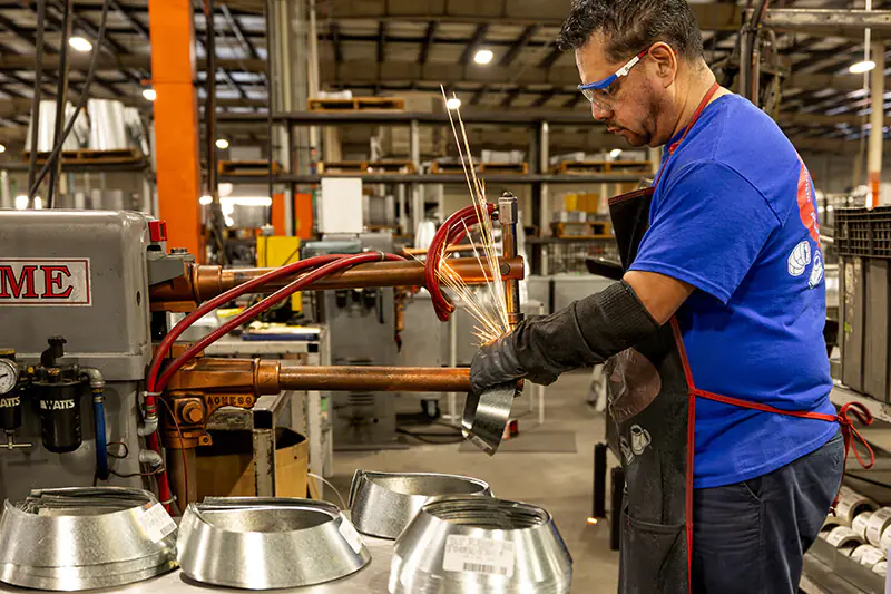 MMF Inc employee operating sheet metal fabrication machinery for HVAC duct products